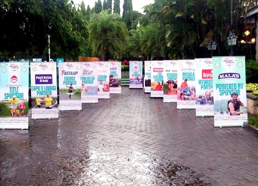 Row of sponsor banners placed along a race venue walkway as part of a multi-city brand activation