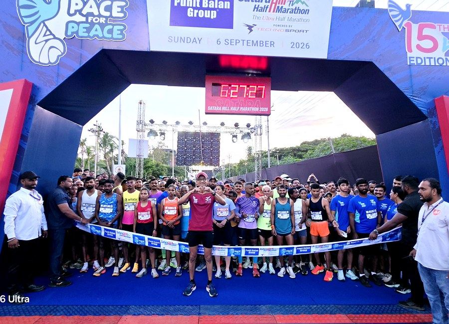 Start line arch and crowd of runners at the Satara Hill Half Marathon, a race managed by Abunduntia